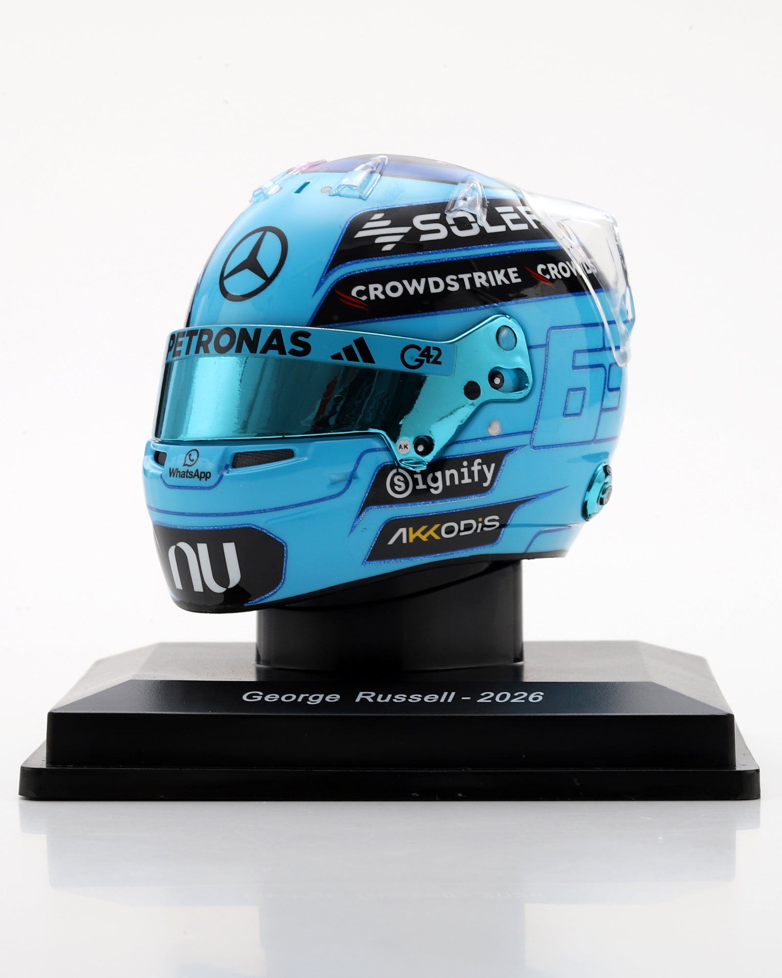 George Russell 2026 1:5 scale replica helmet in light blue with team branding on a black display stand.